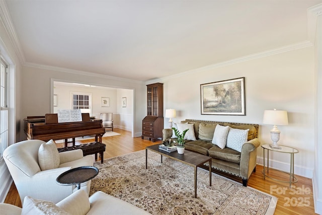 living room with ornamental molding, light wood-type flooring, and baseboards