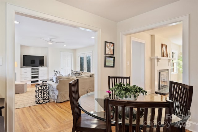 dining room with recessed lighting, ceiling fan, wood finished floors, and a glass covered fireplace