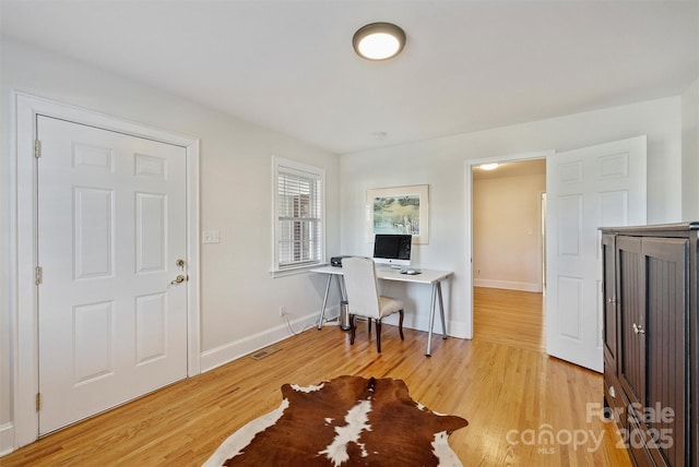 office featuring visible vents, light wood-style flooring, and baseboards