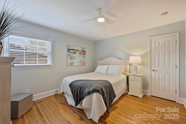 bedroom featuring a ceiling fan, light wood-type flooring, visible vents, and baseboards