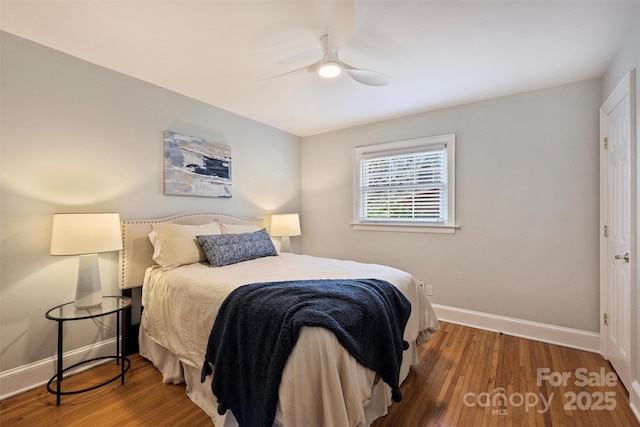 bedroom featuring a ceiling fan, baseboards, and wood finished floors