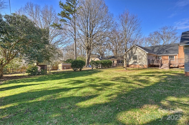 view of yard featuring fence and a deck