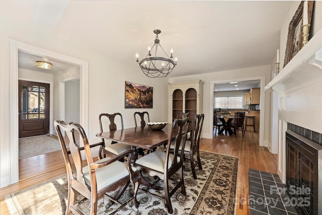 7135 Folger Dr, Charlotte, NC 28270 - dining area with a chandelier, light wood-style flooring, baseboards, and a fireplace