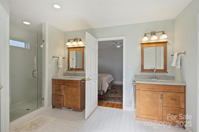 7135 Folger Dr, Charlotte, NC 28270 - bathroom with a shower stall, two vanities, tile patterned floors, a ceiling fan, and baseboards