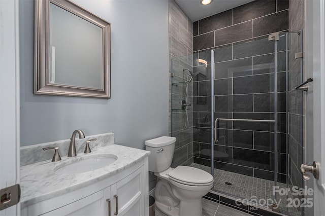 bathroom featuring toilet, tile patterned flooring, a shower with shower door, and vanity