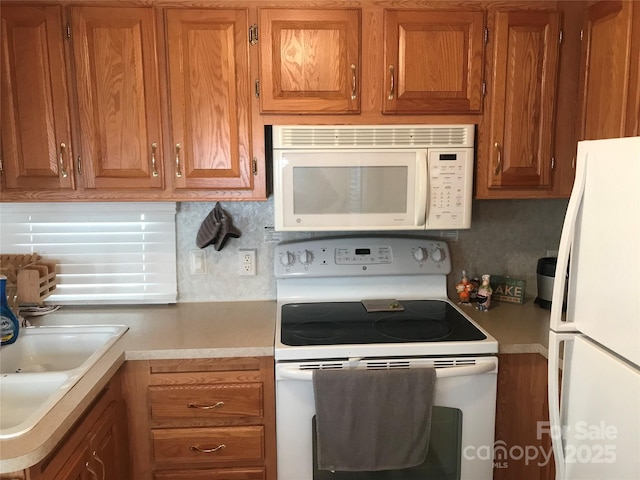 kitchen featuring tasteful backsplash, white appliances, and sink