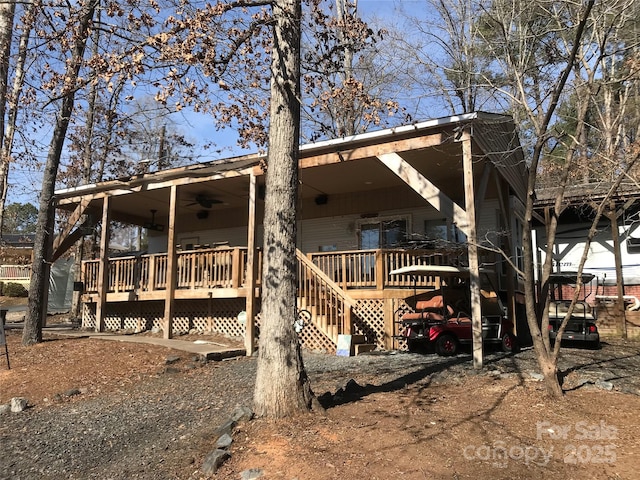 back of property with a wooden deck and ceiling fan