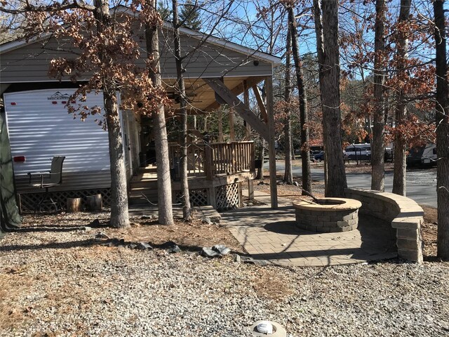 view of yard with a wooden deck and a fire pit