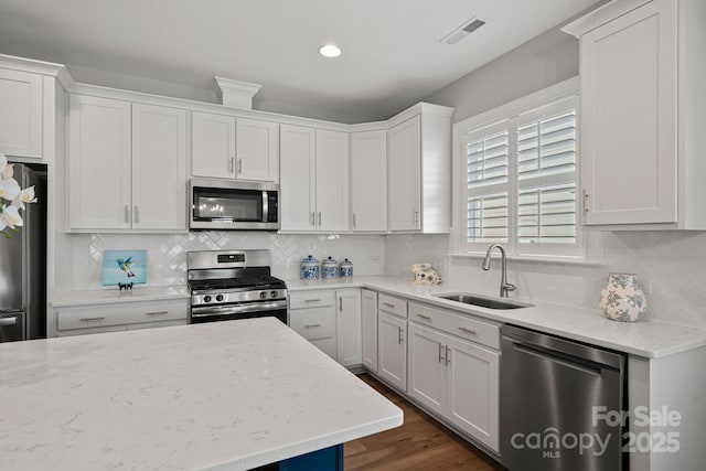 kitchen featuring light stone countertops, sink, white cabinets, and appliances with stainless steel finishes