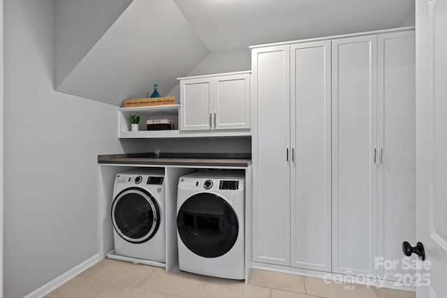 laundry area with cabinets, light tile patterned floors, and washing machine and clothes dryer