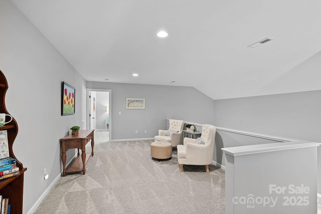 sitting room with vaulted ceiling and light colored carpet