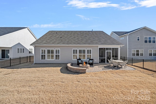 back of house with a lawn, an outdoor fire pit, a patio area, and a sunroom