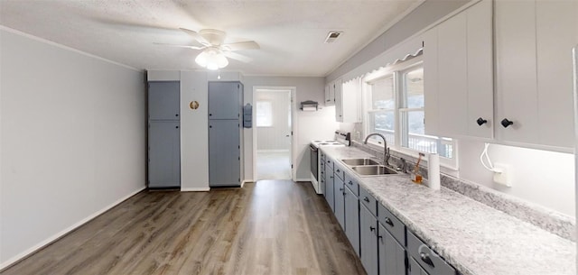 kitchen with electric range, light wood-style flooring, gray cabinets, light countertops, and a sink