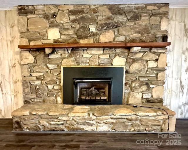 interior details featuring ornamental molding, a fireplace with raised hearth, and wood finished floors