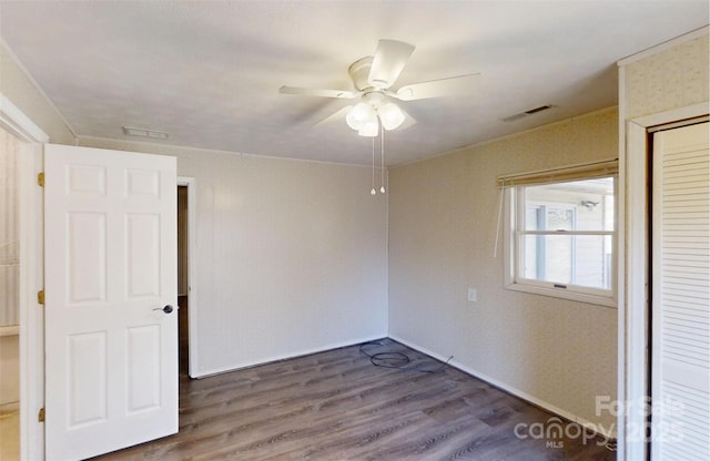 interior space with ceiling fan, visible vents, baseboards, a closet, and dark wood finished floors