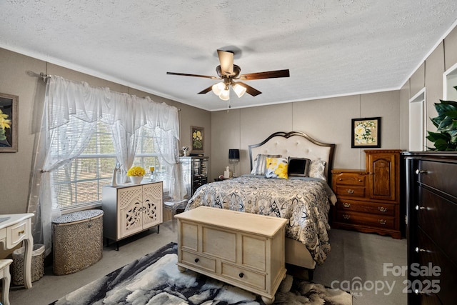 carpeted bedroom with ornamental molding, ceiling fan, and a textured ceiling