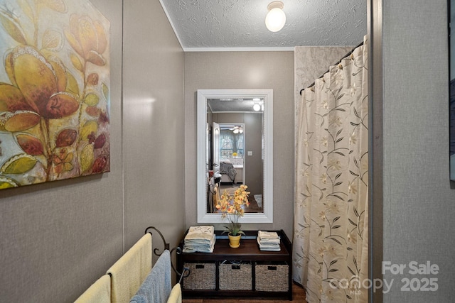 interior space with ornamental molding and a textured ceiling