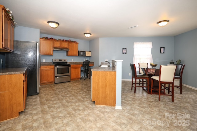 kitchen with sink, stainless steel appliances, and built in desk