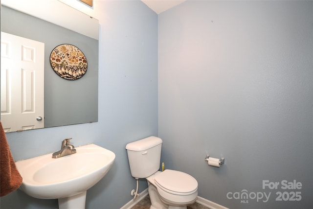 bathroom with sink, toilet, and tile patterned flooring