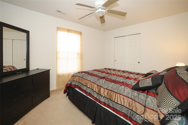 bedroom featuring light carpet, ceiling fan, and a closet