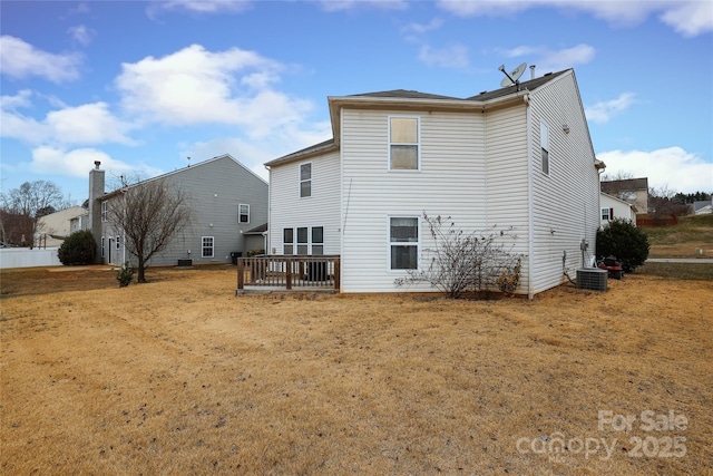 rear view of property featuring a wooden deck, a lawn, and central air condition unit