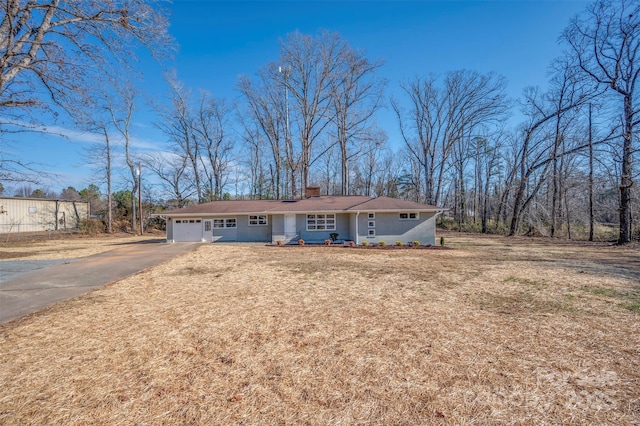 ranch-style house featuring a front lawn and a garage