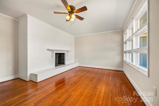 unfurnished living room with ceiling fan, wood-type flooring, ornamental molding, and a fireplace