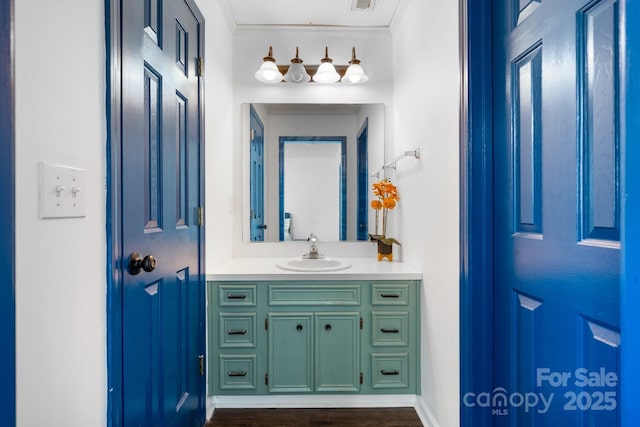 bathroom with vanity, ornamental molding, and wood-type flooring