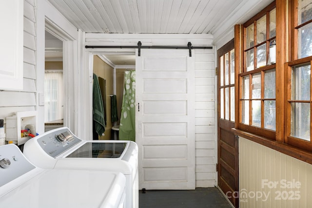 laundry area with washer and dryer, plenty of natural light, and wood walls