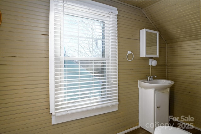 bathroom featuring lofted ceiling, vanity, wood ceiling, and wooden walls