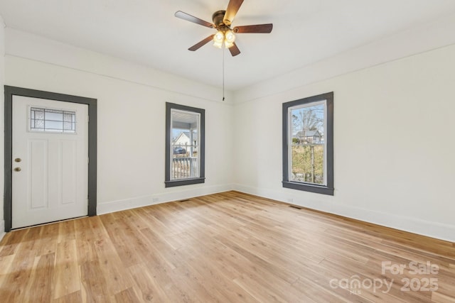 unfurnished room featuring ceiling fan, plenty of natural light, and light wood-type flooring