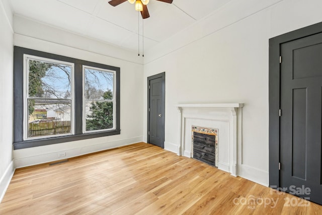 unfurnished living room with hardwood / wood-style flooring and ceiling fan