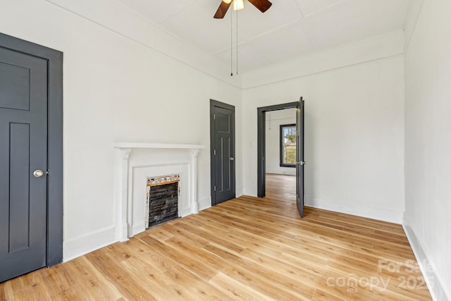 unfurnished living room with ceiling fan and wood-type flooring