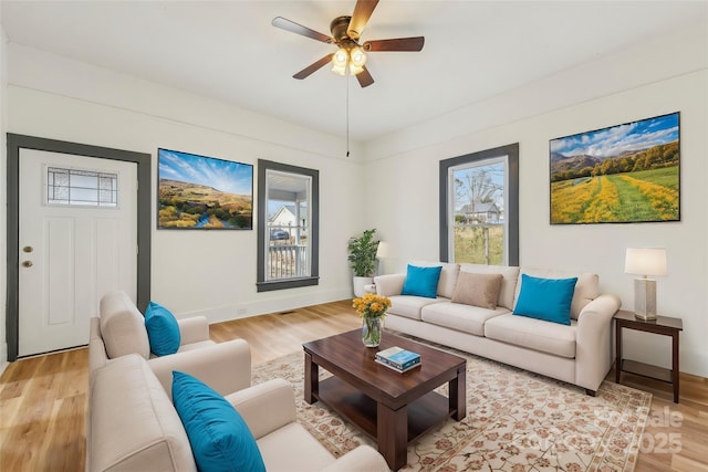 living room featuring ceiling fan and light hardwood / wood-style flooring