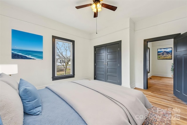 bedroom featuring ceiling fan, wood-type flooring, and a closet