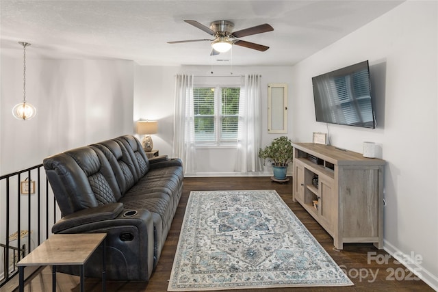 living room featuring ceiling fan and dark hardwood / wood-style floors