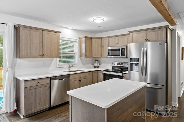 kitchen featuring a textured ceiling, a center island, dark wood-type flooring, stainless steel appliances, and sink