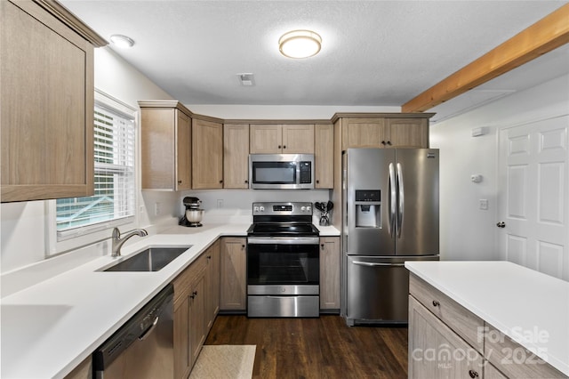 kitchen featuring a textured ceiling, dark wood-type flooring, light brown cabinets, stainless steel appliances, and sink