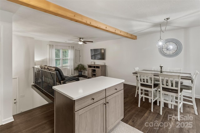 kitchen with light brown cabinets, decorative light fixtures, dark wood-type flooring, a center island, and beamed ceiling