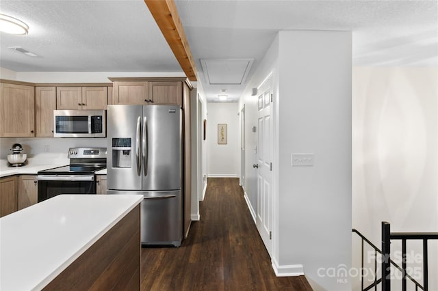 kitchen featuring dark wood-type flooring, a textured ceiling, and stainless steel appliances