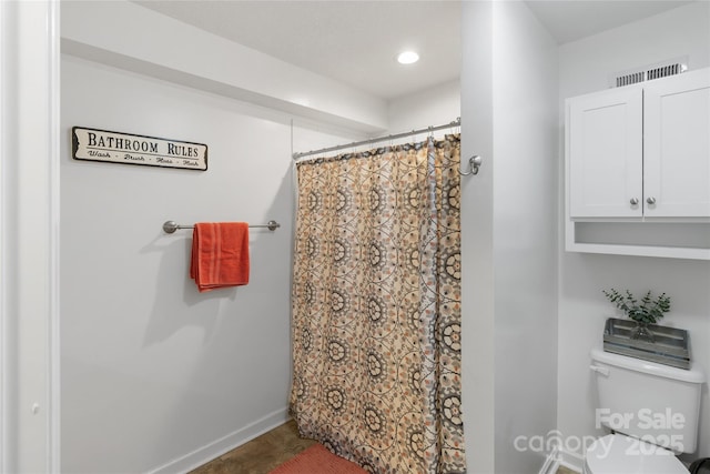 bathroom with curtained shower and toilet