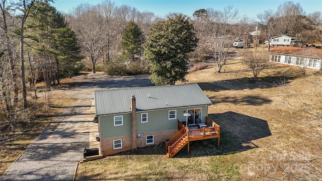 back of house with a deck and a lawn