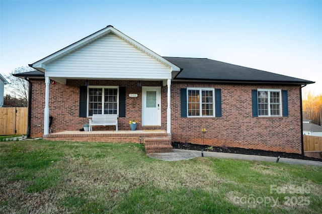 ranch-style house with covered porch and a front lawn