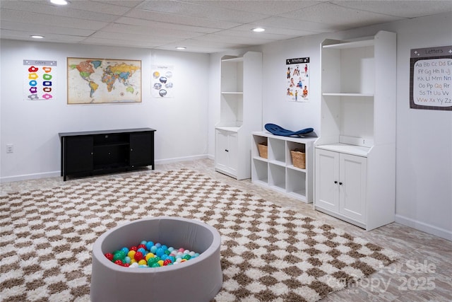 rec room featuring a paneled ceiling and built in shelves