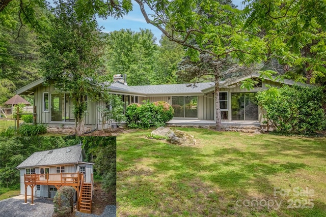 back of house featuring a wooden deck, a lawn, and a sunroom