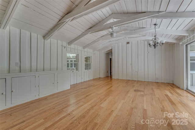 interior space with light hardwood / wood-style floors, lofted ceiling with beams, and an inviting chandelier