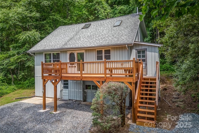 rear view of property featuring a wooden deck