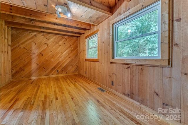 interior space featuring wooden ceiling, beam ceiling, light hardwood / wood-style floors, and wooden walls