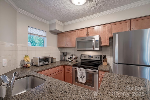 kitchen with a sink, dark stone countertops, a toaster, and stainless steel appliances