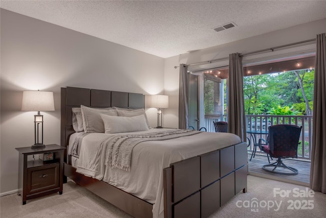 bedroom with visible vents, light carpet, a textured ceiling, and access to exterior